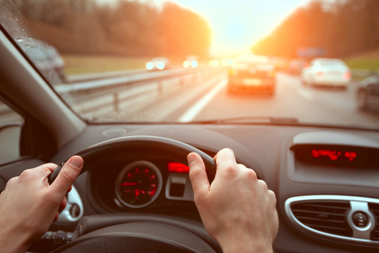 driving on highway road, closeup hands of car driver on steering wheel, road trip
